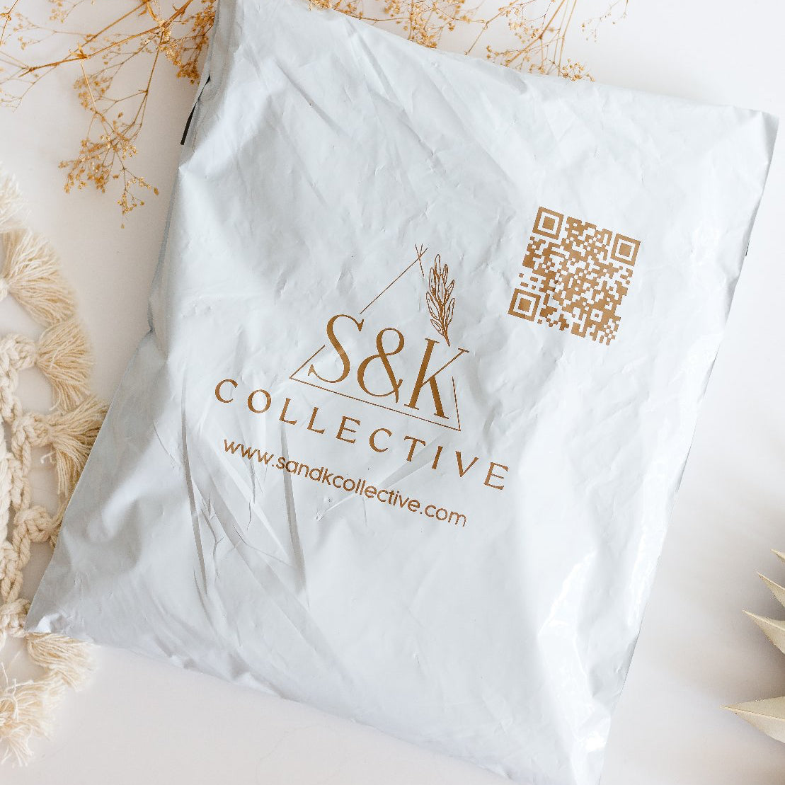 White POLYMAILER with S&K Collective logo and QR code on a decorative background