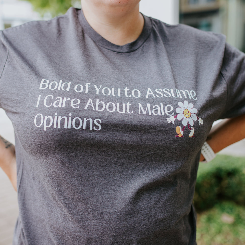 
                  
                    Person wearing a gray t-shirt with a printed message and flowers.
                  
                